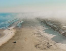 widok na plażę z mgłami z drona